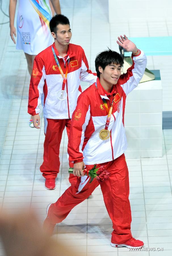 Huo Liang (front) of China greets spectators after the awarding ceremony for the men's 10m platform diving at the 27th Summer Universiade in Kazan, Russia, July 10, 2013. Huo Liang won the gold medal with 531.25. (Xinhua/Kong Hui)