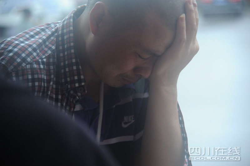 A man cries in a temporary settlement site in flood-hit Zhongxin county , Dujiangyan, southwest China's Sichuan province, July 10, 2013. Rain-triggered mountain torrents and landslides buried 11 households, leaving two people dead and 21 missing. As of 9:45 p.m., 352 people stranded have been relocated to safe areas. (Photo by Fang Wei/scol.com.cn)