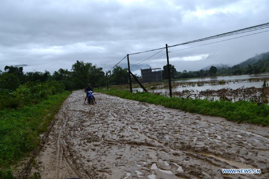 A motorcyclist rides on a mud road after heavy rain in north Vietnamese province Ha Giang, on July 10, 2013. Heavy rains and floods hit many parts of Ha Giang province this month, killing two people and causing huge damage to crops. (Xinhua/VNA)