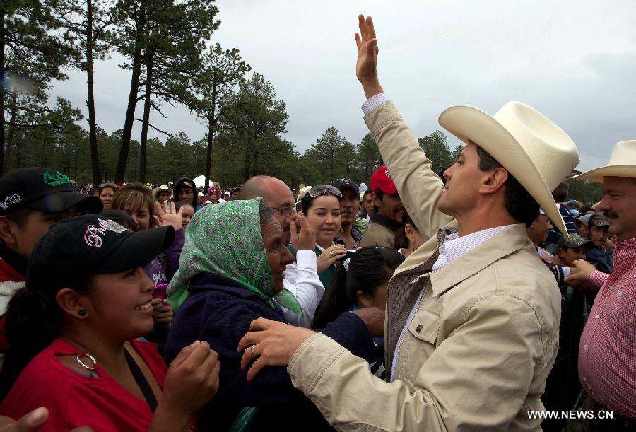 Image provided by the Mexican Presidency shows Mexican President Enrique Pena Nieto (R) during the commemoration of the "Tree Day" in Balleza, in the state of Chihuahua, Mexico, on July 10, 2013. Enrique Pena Nieto, announced that 180 million trees will be planted in the country. (Xinhua/Mexican Presidency)