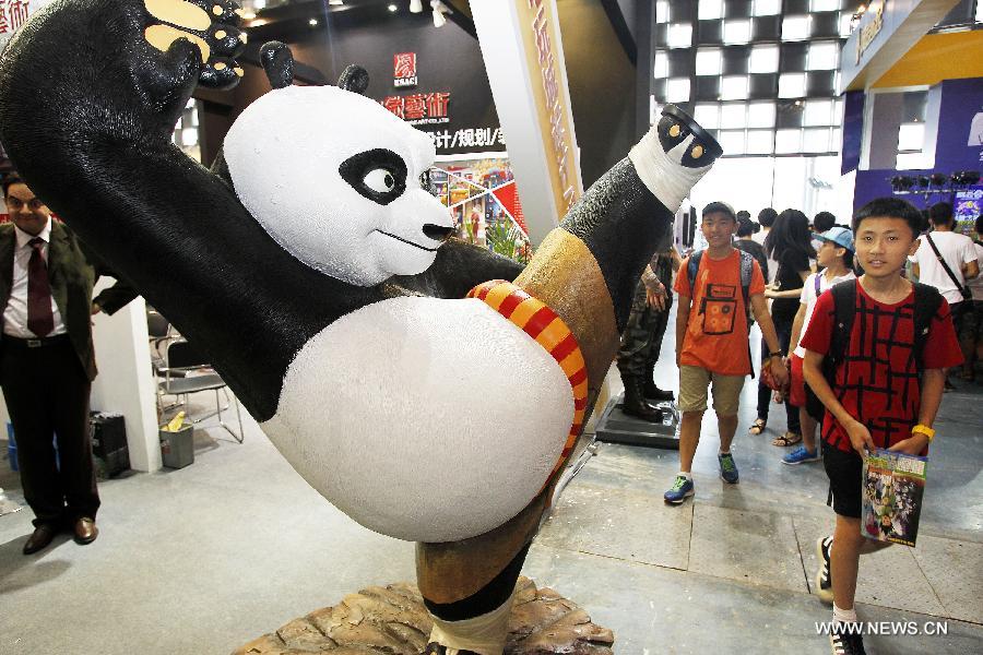 Visitors walk past a model of cartoon character "Kung Fu Panda" at the 9th China International Comics Games Expo (CCG Expo) in Shanghai, east China, July 11, 2013. A total of 325 animation and game companies from at home and abroad took part in the five-day expo, which kicked off here on Thursday. (Xinhua/Ding Ting)  