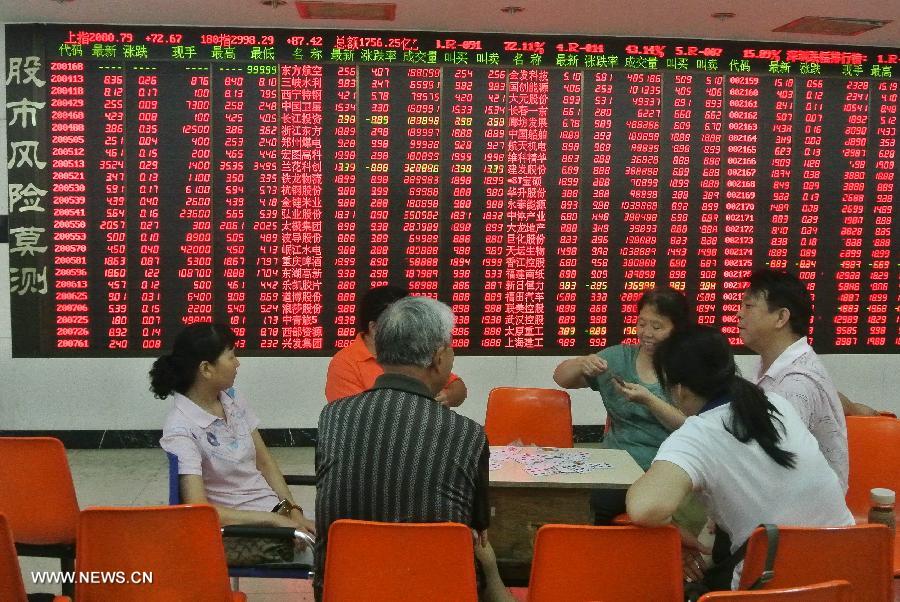 Investors play cards at a trading hall of a securities firm in Beijing, capital of China, July 11, 2013. Chinese shares jumped to a three-week high Thursday over media reports that financing rules may be partially relaxed for real estate firms. The benchmark Shanghai Composite Index jumped 3.23 percent, or 64.86points, to end at 2,072.99. The Shenzhen Component Index soared 4.25 percent, or 333.52 points, to 8,184.77. (Xinhua/Li Xin)