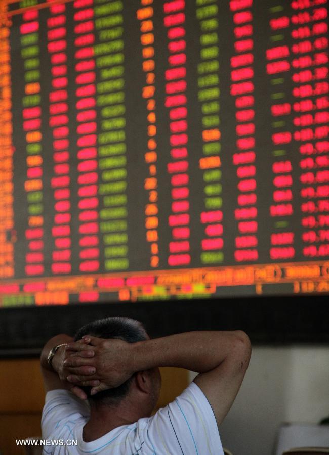 An investor looks at a screen showing stock information at a trading hall of a securities firm in Shanghai, east China, July 11, 2013. Chinese shares jumped to a three-week high Thursday over media reports that financing rules may be partially relaxed for real estate firms. The benchmark Shanghai Composite Index jumped 3.23 percent, or 64.86points, to end at 2,072.99. The Shenzhen Component Index soared 4.25 percent, or 333.52 points, to 8,184.77. (Xinhua/Zhuang Yi)