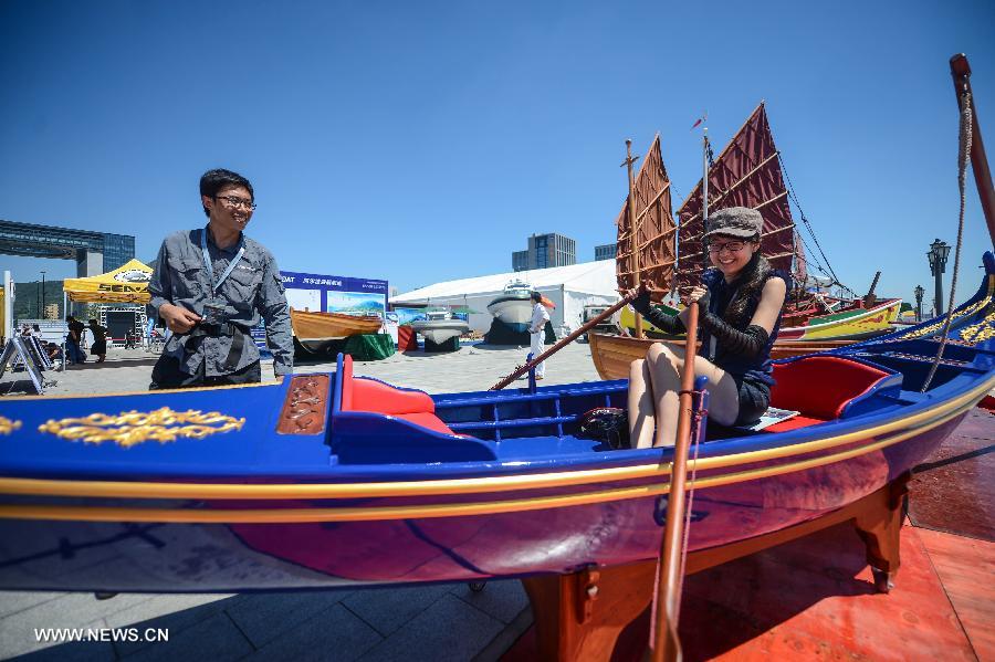A visitor experiences in a boat presented in the 2013 China (Zhoushan archipelago) International Boat Show in the Putuo District of Zhoushan City, east China's Zhejiang Province, July 11, 2013. The show kicked off on Thursday. (Xinhua/Xu Yu)