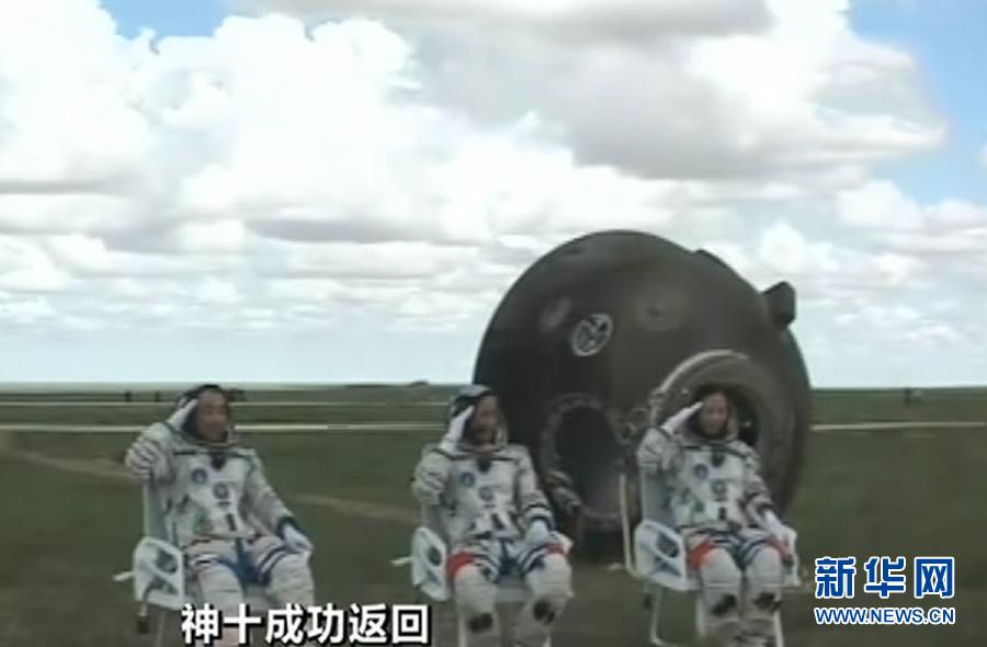 Astronauts Zhang Xiaoguang, Nie Haisheng and Wang Yaping (from left to right) salute to people after going out of the re-entry capsule of China's Shenzhou-10 spacecraft following its successful landing at the main landing site in north China's Inner Mongolia Autonomous Region on June 26, 2013. (Xinhua) 