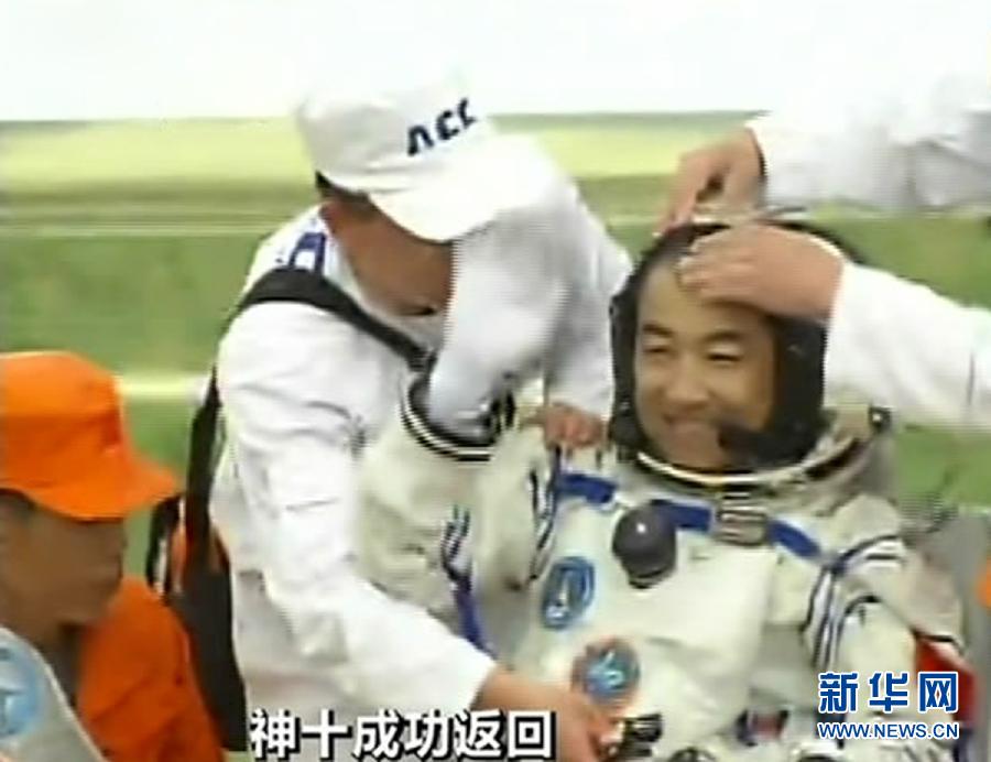 Astronaut Zhang Xiaoguang waves to people after going out of the re-entry capsule of China's Shenzhou-10 spacecraft on June 26, 2013. (Xinhua)