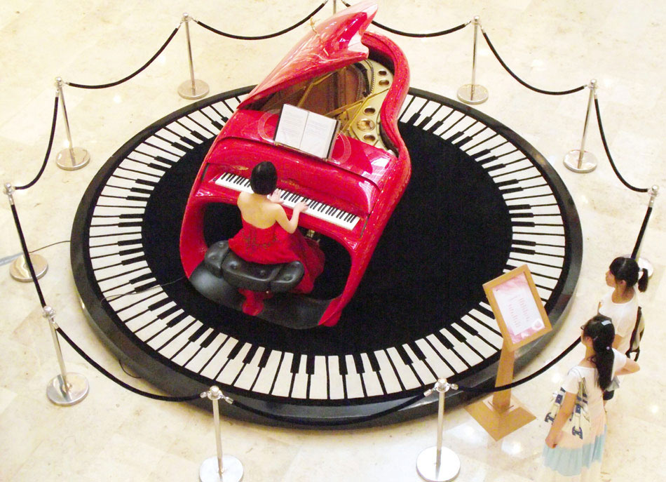 A musician plays a Shimmel Pegasus piano on Tuesday at the atrium of a shopping mall in Nanjing, Jiangsu province. Shimmel Pegasus pianos, which are made in Germany, are considered luxury products. (Photo/China Daily)
