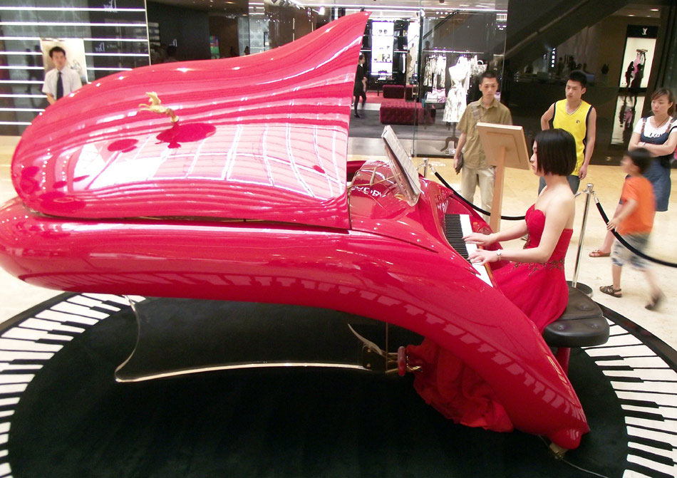 A musician plays a Shimmel Pegasus piano on Tuesday at the atrium of a shopping mall in Nanjing, Jiangsu province. Shimmel Pegasus pianos, which are made in Germany, are considered luxury products. (Photo/China Daily)