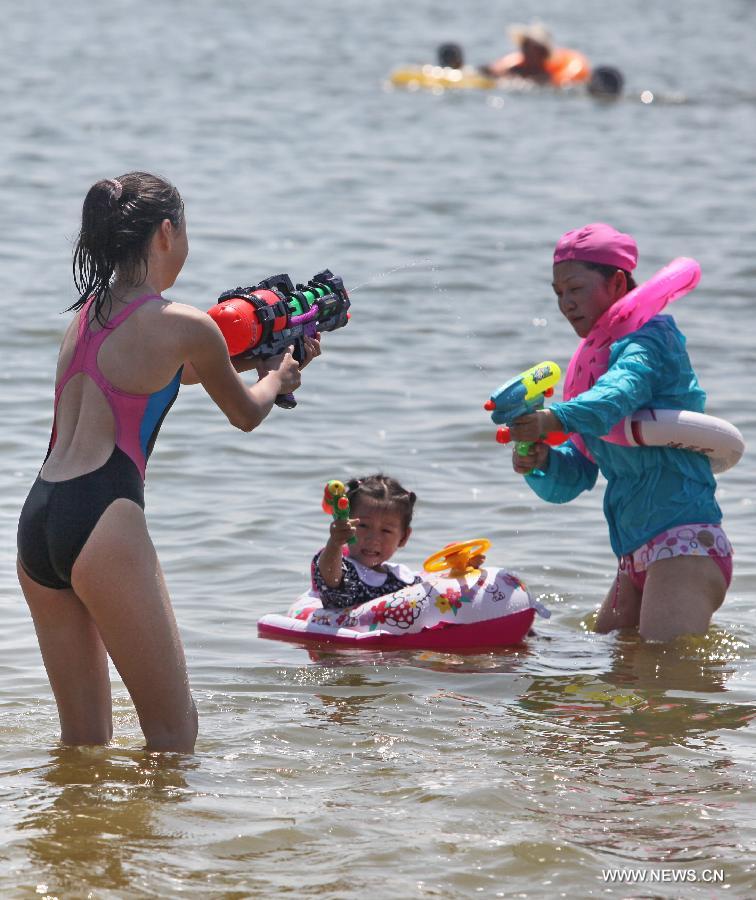 Tourists cool off on the beach in Shanghai, east China, July 11, 2013. The highest temperature in Shanghai reached 38.4 degrees Celsius on Thursday. (Xinhua/Zhuang Yi)