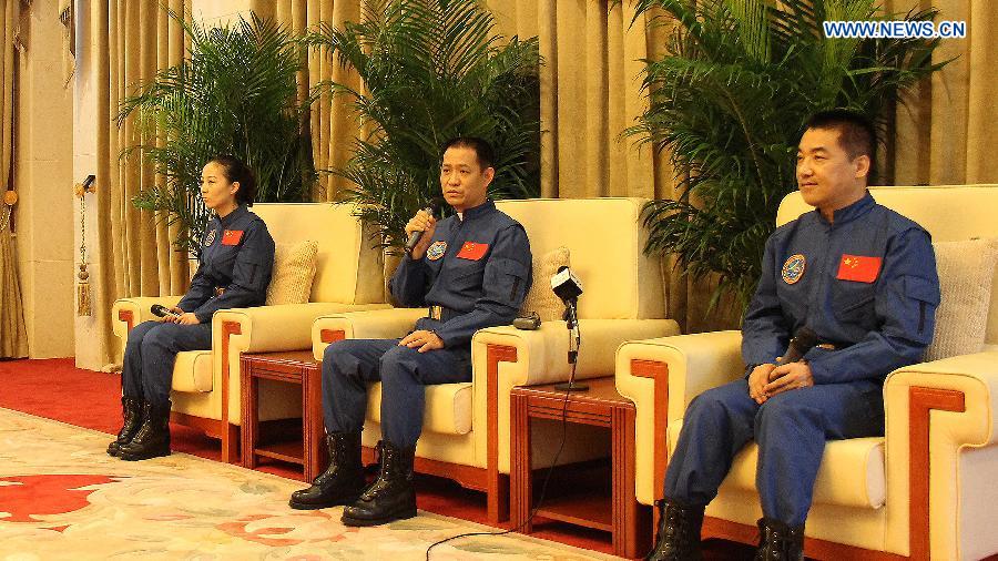 Nie Haisheng (C), astronaut of China's Shenzhou-10 mission, answers questions at a press conference in Beijing, China, July 11, 2013. Nie Haisheng, Zhang Xiaoguang and Wang Yaping, the three astronauts of China's Shenzhou-10 mission, have completed their medical quarantine and are in good conditions, according to official sources. (Xinhua/Liu Fang) 