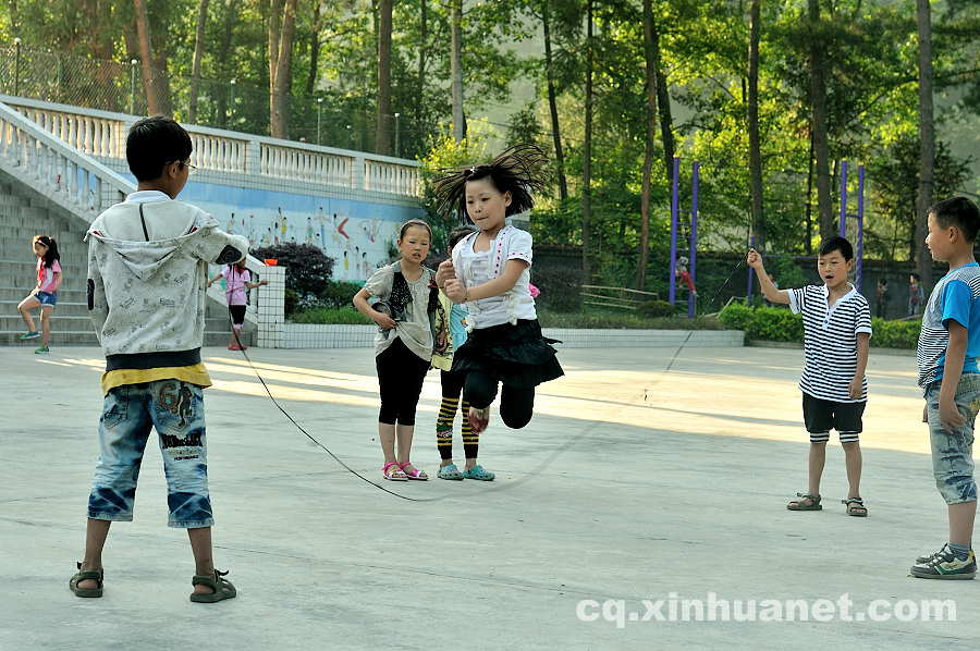 A girl plays with her classmates on the playground. As a part of the eco-migration project which aims to help the poor overcome extreme difficulties, new houses and public schools were built in the settlement community in Lantian town, Chengkou county, southwest China’s Chongqing. (Xinhua Photo/ Li Xiangbo)