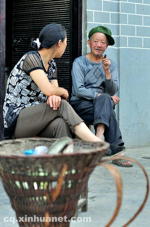 Two people chat in front of their newly built houses in the eco-migration community. The eco-migration project aims to help the poor overcome extreme difficulties in Lantian town, Chengkou county, southwest China’s Chongqing. (Xinhua Photo/ Li Xiangbo)