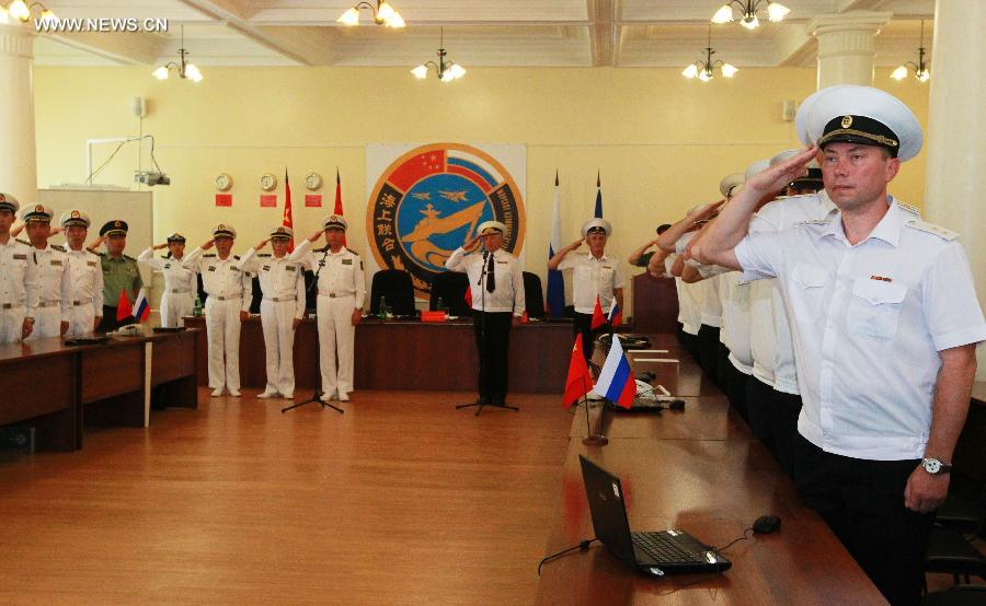 Naval officers from China and Russia salute at the closing ceremony of the joint naval drills in Vladivostok, Russia, July 11, 2013. Ding Yiping, deputy commander of the Chinese Navy and director of the "Joint Sea-2013" drill, announced the end of the joint naval drills here on Thursday. (Xinhua/Zha Chunming)