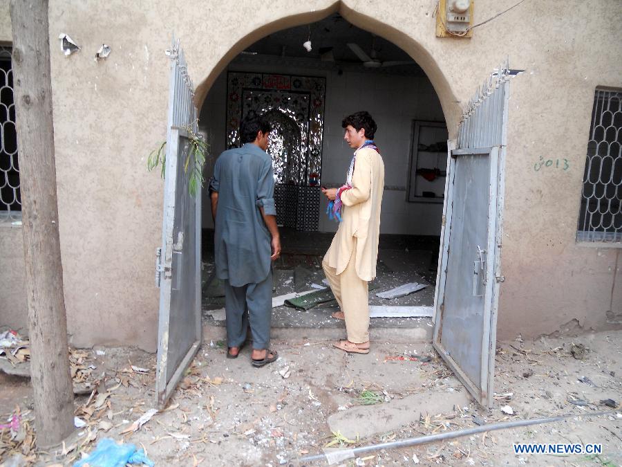 People examine a damaged mosque at the blast site in northwest Pakistan's Kohat, July 11, 2013. At least three people were killed and 10 others injured when a bomb went off outside a mosque in Pakistan's northwest Kohat district on Thursday afternoon, local Urdu media reported. (Xinhua/Stringer)