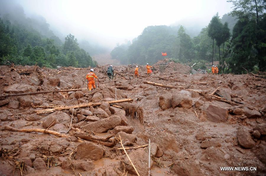 Fire fighters walk on muds while searching for survivors at the Sanxi Village, in Dujiangyan City, southwest China's Sichuan Province, July 11, 2013. As of 2:10 p.m. Thursday, rescuers had found 18 bodies from the landslide that happened on Wednesday morning in the village of Sanxi. (Xinhua/Xue Yubin)