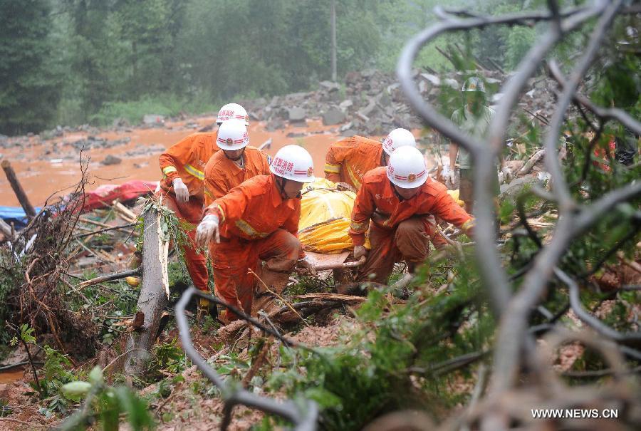 Fire fighters carry a body on muds while searching for survivors at the Sanxi Village, in Dujiangyan City, southwest China's Sichuan Province, July 11, 2013. As of 2:10 p.m. Thursday, rescuers had found 18 bodies from the landslide that happened on Wednesday morning in the village of Sanxi. (Xinhua/Xue Yubin)