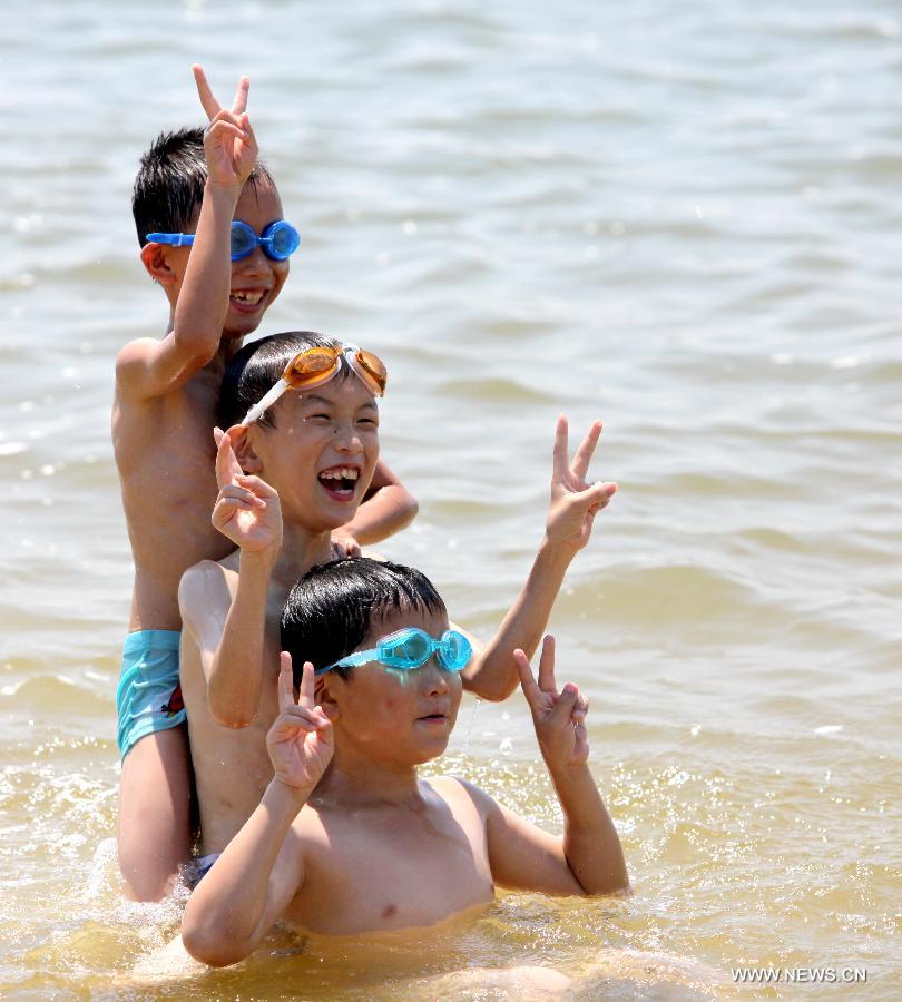 Tourists cool off on the beach in Shanghai, east China, July 11, 2013. The highest temperature in Shanghai reached 38.4 degrees Celsius on Thursday. (Xinhua/Zhuang Yi)