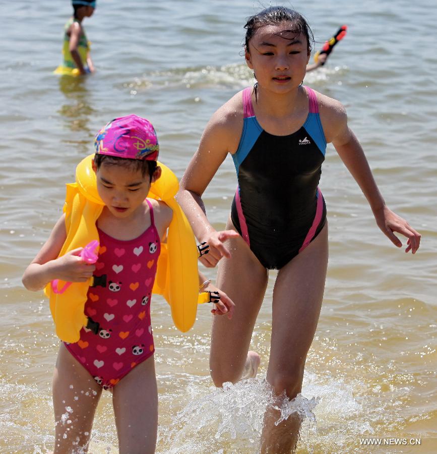 Tourists cool off on the beach in Shanghai, east China, July 11, 2013. The highest temperature in Shanghai reached 38.4 degrees Celsius on Thursday. (Xinhua/Zhuang Yi)