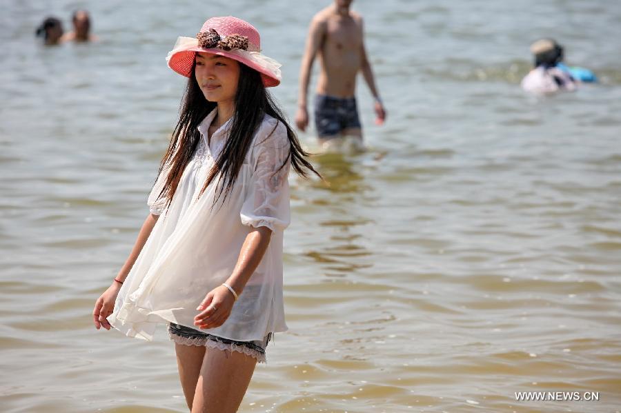 Tourists cool off on the beach in Shanghai, east China, July 11, 2013. The highest temperature in Shanghai reached 38.4 degrees Celsius on Thursday. (Xinhua/Zhuang Yi)