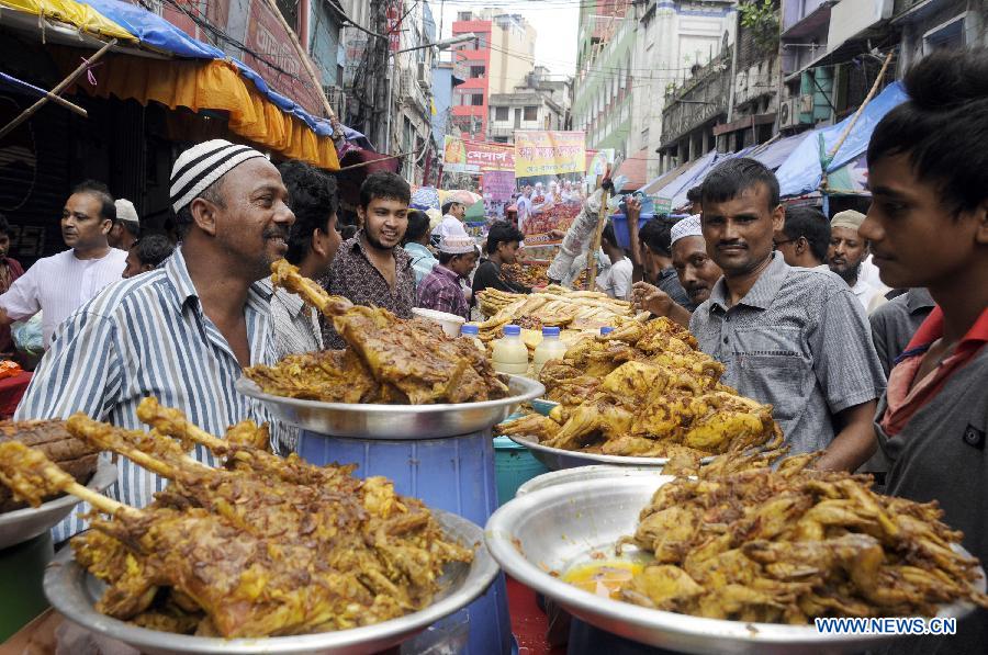 Vendors prepare ifter, food for breaking the daytime fast during the Islamic holy month of Ramadan, at a traditional ifter bazaar in Dhaka, Bangladesh, July 11, 2013. Ramadan is the Muslim month of fasting, during which Muslims refrain from eating, drinking, smoking from sunrise to sunset. (Xinhua/Shariful Islam)