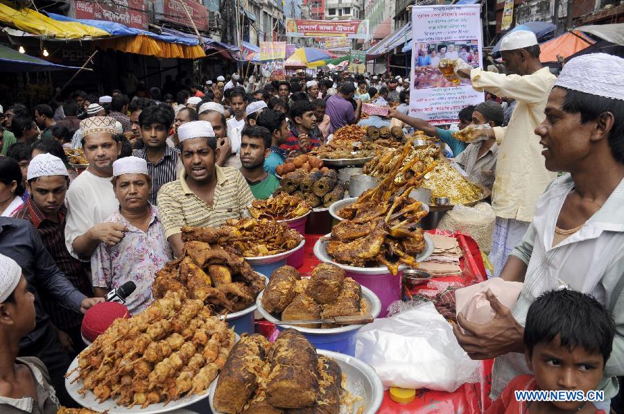 Bangladeshi Muslims buy ifter, food for breaking the daytime fast during the Islamic holy month of Ramadan, at a traditional ifter bazaar in Dhaka, Bangladesh, July 11, 2013. Ramadan is the Muslim month of fasting, during which Muslims refrain from eating, drinking, smoking from sunrise to sunset. (Xinhua/Shariful Islam) 