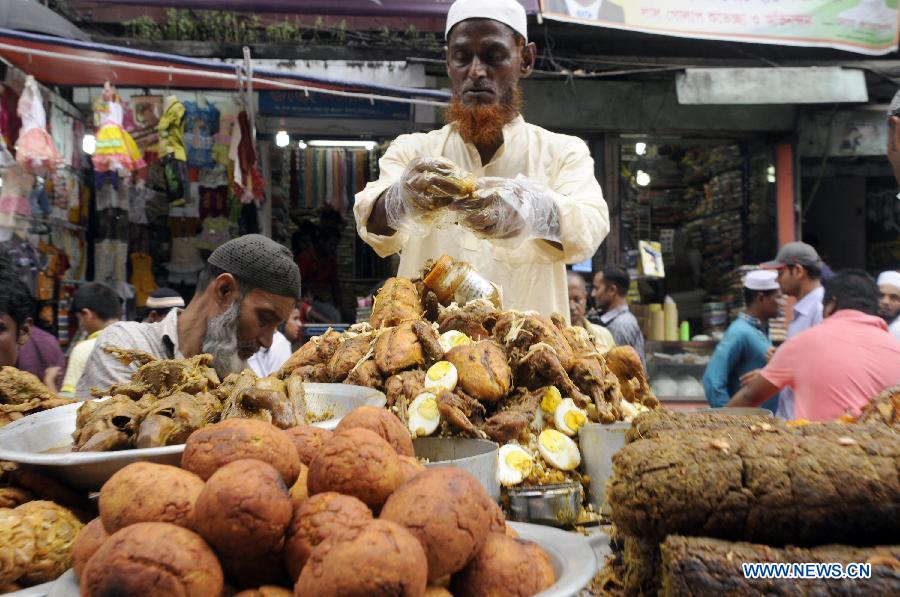 A vendor prepares ifter, food for breaking the daytime fast during the Islamic holy month of Ramadan, at a traditional ifter bazaar in Dhaka, Bangladesh, July 11, 2013. Ramadan is the Muslim month of fasting, during which Muslims refrain from eating, drinking, smoking from sunrise to sunset. (Xinhua/Shariful Islam)