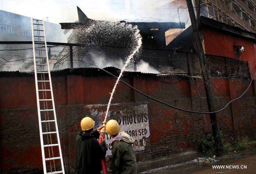 Firefighters try to distinguish the fire in a building on the premises of Civil Secretariat in Srinagar, the summer capital of Indian-controlled Kashmir, July 11, 2013. Massive fire broke out Thursday in a building on the premises of Civil Secretariat in Srinagar, the summer capital of Indian-controlled Kashmir, officials said. (Xinhua/Javed Dar)