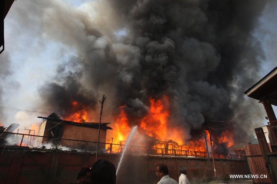 Firefighters try to distinguish the fire in a building on the premises of Civil Secretariat in Srinagar, the summer capital of Indian-controlled Kashmir, July 11, 2013. Massive fire broke out Thursday in a building on the premises of Civil Secretariat in Srinagar, the summer capital of Indian-controlled Kashmir, officials said. (Xinhua/Javed Dar) 