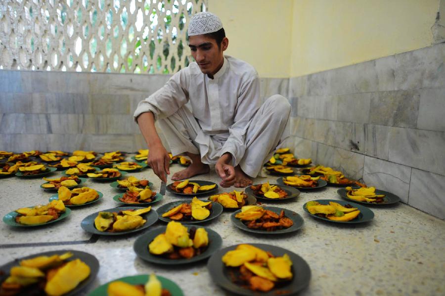 A Pakistani man arrange food for Muslim devotees before breaking their fast at a mosque during the first day of the Muslim fasting month of Ramadan in northwest Pakistan's Peshawar on July 11, 2013. Iftar refers to the evening meal when Muslims break their fast during the holly month of Ramadan, a season of fasting and spiritual reflection. (Xinhua/Ahmad Sidique) 