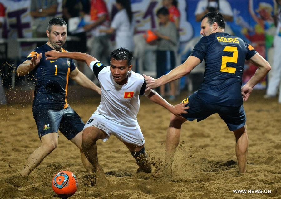 Phung Tan Hung (C) of Vietnam competes during the men's beach soccer match against Australia at the 4th Asian Beach Games in Haiyang, east China's Shandong Province, July 11, 2013. Vietnam lost 2-7. (Xinhua/Zhu Zheng)