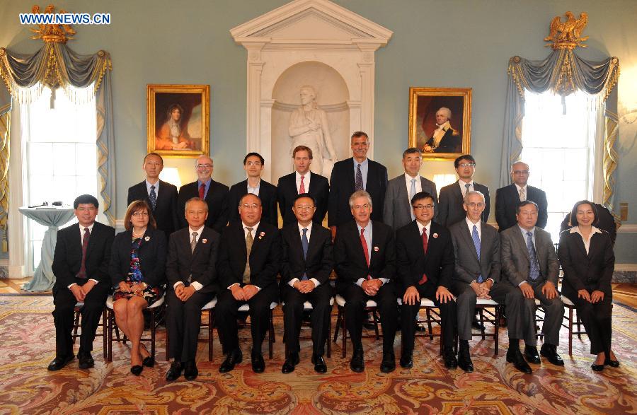 Representatives of enterprisers from both China and the United States pose for a group photo with Yang Jiechi (5th L, Front), Chinese State Councilor and special representative of Chinese President Xi Jinping, and U.S. Deputy Secretary of State William Burns (6th L, Front) at a signing ceremony of China-U.S. EcoPartnership program in Washington, the United States, July 11, 2013. China and the United Sates on Thursday expanded their EcoPartnership program with the signing of six new partnerships to reduce greenhouse gases emissions and improve energy efficiency as well as to create jobs. (Xinhua/Wang Lei)