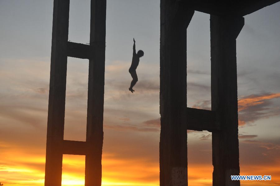 A local resident dives into the Wanquan River in Qionghai City, south China's Hainan Province, July 11, 2013. (Xinhua/Meng Zhongde)