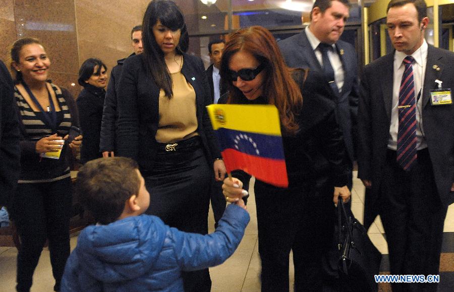 Argentina's President Cristina Fernandez (C) greets a child as she arrives in Montevideo, capital of Uruguay, on July 11, 2013. Cristina Fernandez arrived here Thursday for the next day's Southern Common Market (MERCOSUR) summit. (Xinhua/Analia Garelli/TELAM)