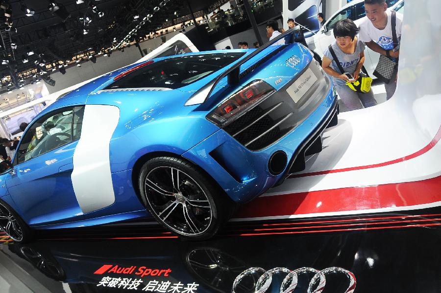 Visitors view an Audi vehicle at the 10th China Changchun International Automobile Expo in Changchun, capital of northeast China's Jilin Province, July 12, 2013. A total of 146 auto brands from 127 companies took part in the ten-day expo, which kicked off here on Friday. (Xinhua/Lin Hong)