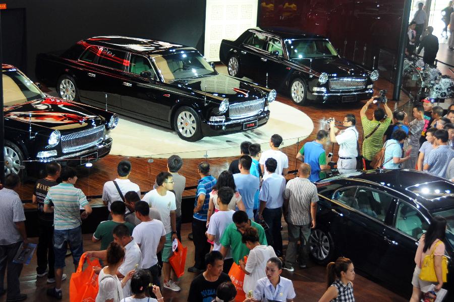 Visitors view the Hongqi vehicles of China's First Automobile Works (FAW) at the 10th China Changchun International Automobile Expo in Changchun, capital of northeast China's Jilin Province, July 12, 2013. A total of 146 auto brands from 127 companies took part in the ten-day expo, which kicked off here on Friday. (Xinhua/Lin Hong)