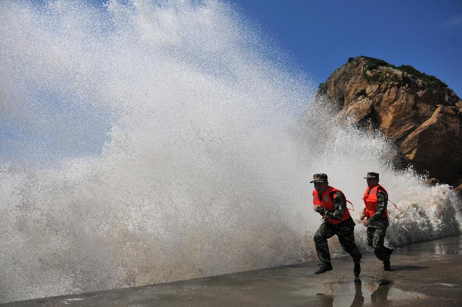 Soldiers carry out patrol duty at the seaside in Diaobang Harbour of Wenling City, east China's Zhejiang Province, July 12, 2013. The highest wave monitored off the southern Zhejiang coast reaches 5.5 meters high, as the Typhoon Soulik approaches. (Xinhua/Jia Ce)