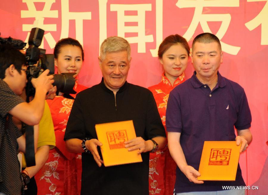 Chinese director Feng Xiaogang (R front) and comedian Zhao Benshan (L front) receive offers working for China Central Television (CCTV)'s 2014 Spring Festival Gala at a press conference in Beijing, China, July 12, 2013. Feng will be the general director of CCTV's 2014 Spring Festival Gala, CCTV announced on Friday. Zhao will be deputy general director in charge of the gala's comedy programming. (Xinhua/Wang Zhen) 