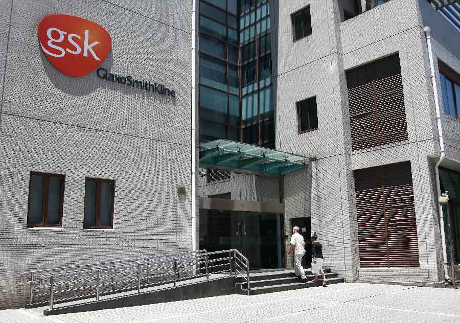 Staff members enter the research center of GlaxoSmithKline (GSK), Britain's biggest drug maker, in Shanghai, east China, July 12, 2013. Some senior executives from GlaxoSmithKline(China) Investment Co., Ltd are being investigated for suspected bribery and tax-related violations, Chinese police said Thursday. (Xinhua/Yang Shichao) 