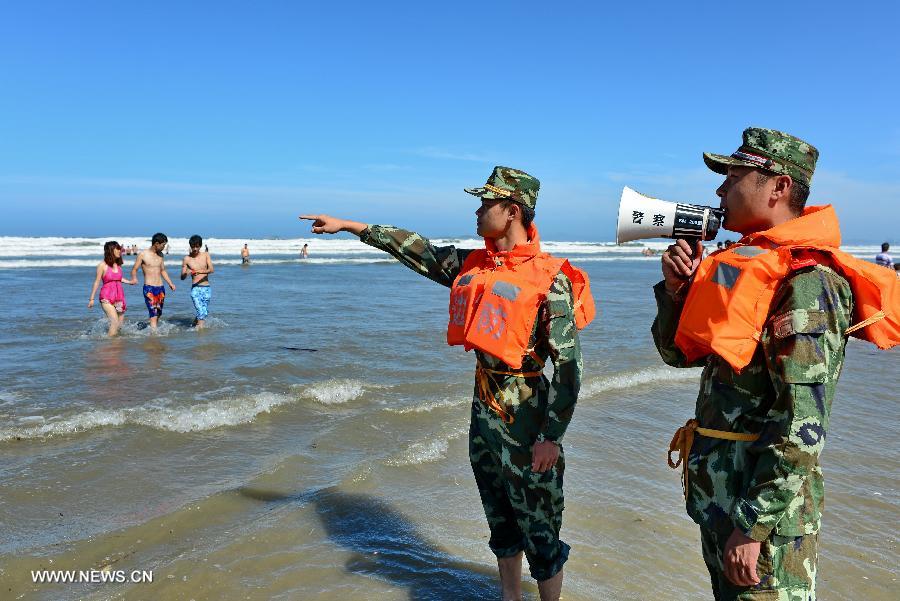 Officers persuade visitors who swim in the sea to go ashore at a bathing beach in Changle, southeast China's Fujian Province, July 12, 2013. Typhoon Soulik is expected to hit or pass waters near southeast China's Taiwan late Friday or early Saturday morning before landing on the mainland on Saturday, according to the National Marine Environmental Forecasting Center. (Xinhua/Zhang Guojun) 