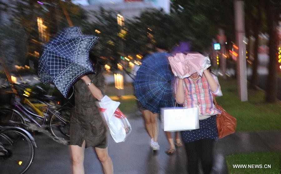 Citizens walk against rain and wind in Taipei, southeast China's Taiwan, July 12, 2013. Typhoon Soulik is expected to hit or pass waters near Taiwan late Friday or early Saturday morning before landing on the mainland on Saturday, according to the National Marine Environmental Forecasting Center. (Xinhua/Tao Ming) 