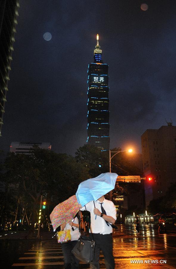 Citizens walk against rain and wind in Taipei, southeast China's Taiwan, July 12, 2013. Typhoon Soulik is expected to hit or pass waters near Taiwan late Friday or early Saturday morning before landing on the mainland on Saturday, according to the National Marine Environmental Forecasting Center. (Xinhua/Tao Ming) 
