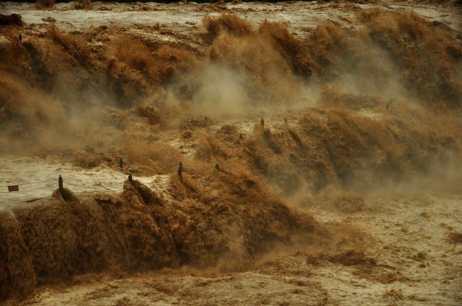 Photo taken on July 12, 2013 shows the Hukou Waterfall of the Yellow River from the site in Jixian County, north China's Shanxi Province. Triggered by non-stop heavy rainfall in the upper reaches, the rising water level of the Yellow River surged the Hukou Waterfall, attracting many visitors. (Xinhua/Lu Guiming) 