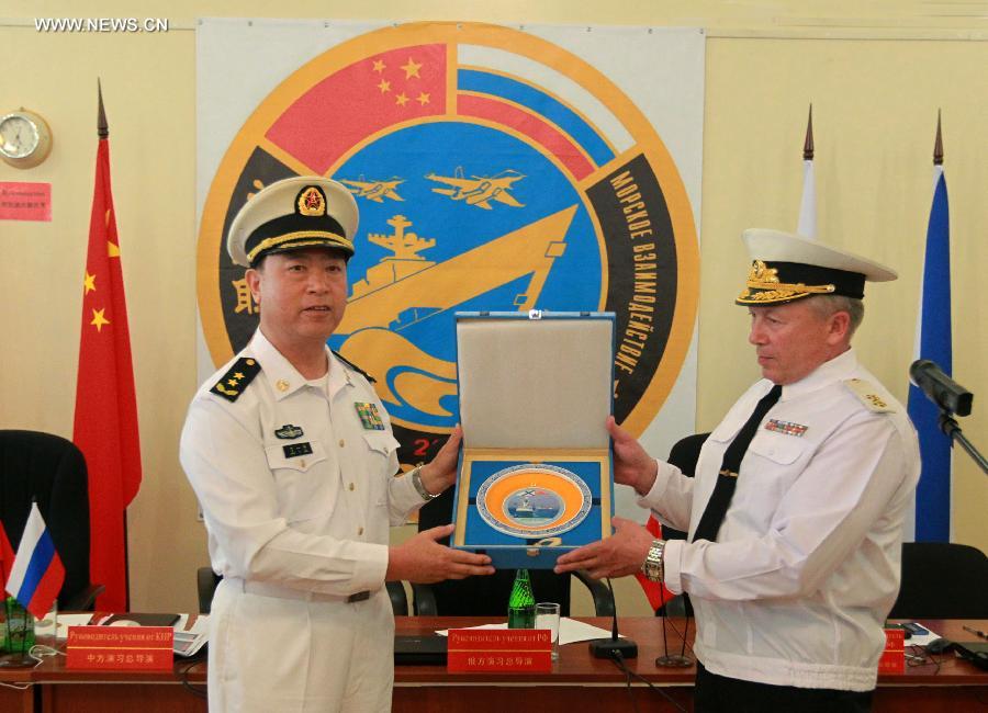 Directors of "Joint Sea-2013" drill from China andRussiaexchange gifts at the closing ceremony of the joint naval drills in Vladivostok, Russia, July 11, 2013. Ding Yiping, deputy commander of the Chinese Navy and director of the "Joint Sea-2013" drill, announced the end of the joint naval drills here on Thursday. (Xinhua/Zha Chunming)