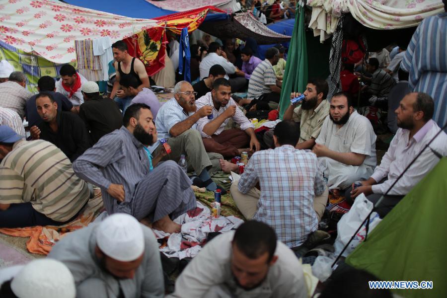 Supporters of ousted Egyptian President Mohamed Morsi break their fast on the third day of Ramadan during a protest near the Rabaa al-Adawiya mosque, in Cairo, Egypt, July 12, 2013. (Xinhua/Wissam Nassar) 