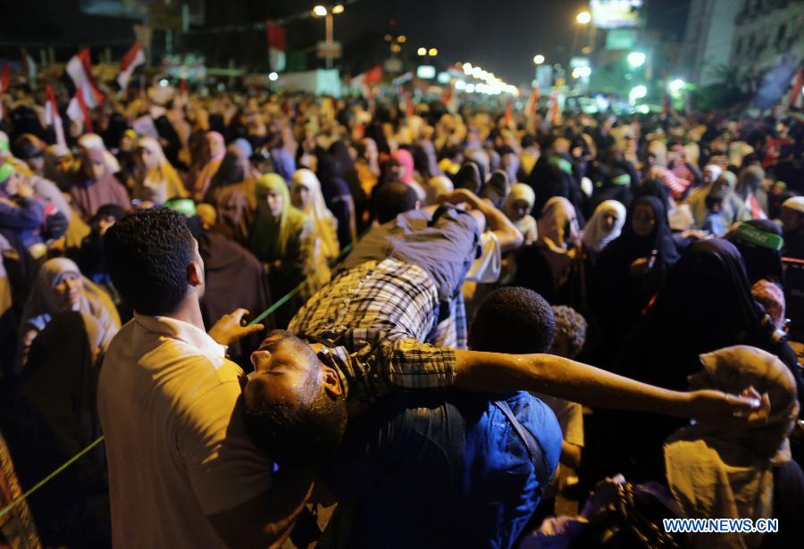 A protester faints during a pro-Morsi protest near the Rabaa al-Adawiya mosque, in Cairo, Egypt, July 12, 2013. (Xinhua/Wissam Nassar) 