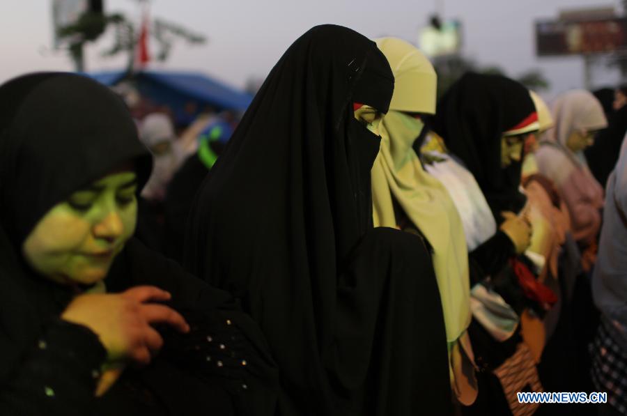 Supporters of ousted Egyptian President Mohamed Morsi pray before breaking their fast on the third day of Ramadan during a protest near the Rabaa al-Adawiya mosque, in Cairo, Egypt, July 12, 2013. (Xinhua/Wissam Nassar) 