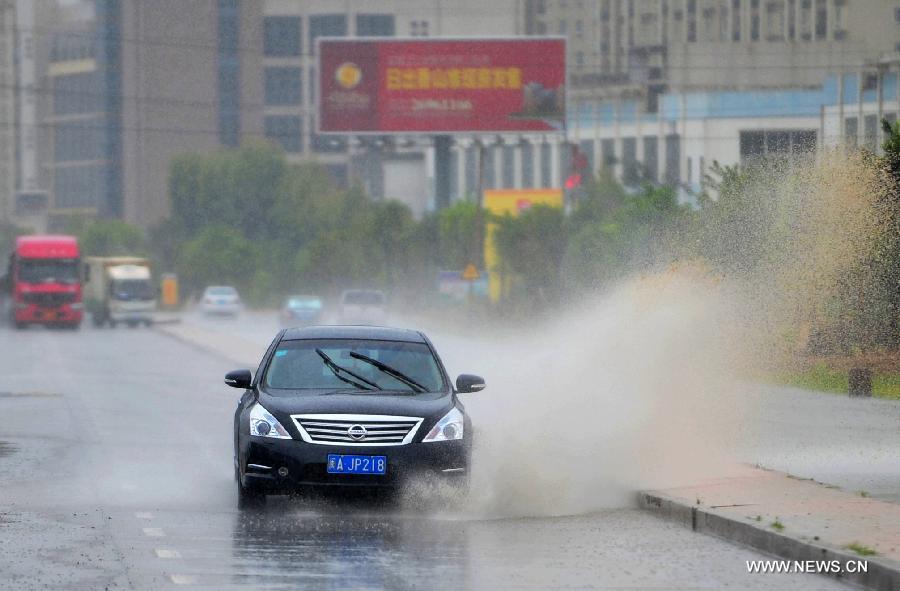 A car travels in a flooded street in the Luoyuan County, southeast China's Fujian Province, July 13, 2013. The local meteorological authority issued a red alert against typhoon as Typhoon Soulik approaches, bringing strong wind and rainstorms to the region. (Xinhua/Wei Peiquan) 