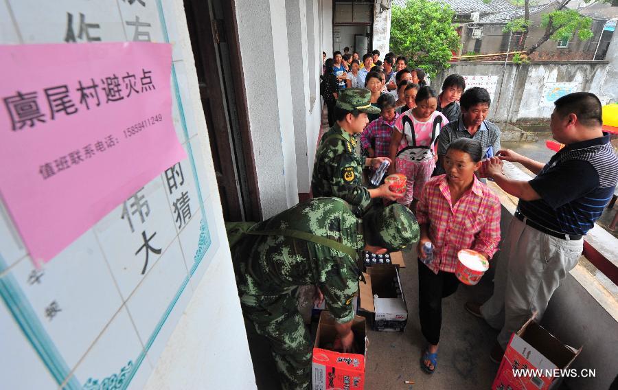 Officers deliver foods to local residents in the Linwei Village of the Luoyuan County, southeast China's Fujian Province, July 13, 2013. The local meteorological authority issued a red alert against typhoon as Typhoon Soulik approaches, bringing strong wind and rainstorms to the region. (Xinhua/Wei Peiquan) 