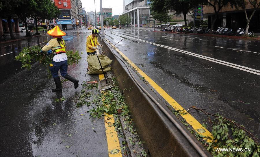 Working staff clean the branches on the road in Taipei, southeast China's Taiwan, July 13, 2013. Traffic in Taipei was interrupted since many trees were uprooted and fell on roads. One person has been confirmed dead and 21 others injured as Typhoon Soulik hit the city on early Saturday morning. (Xinhua/Tao Ming) 