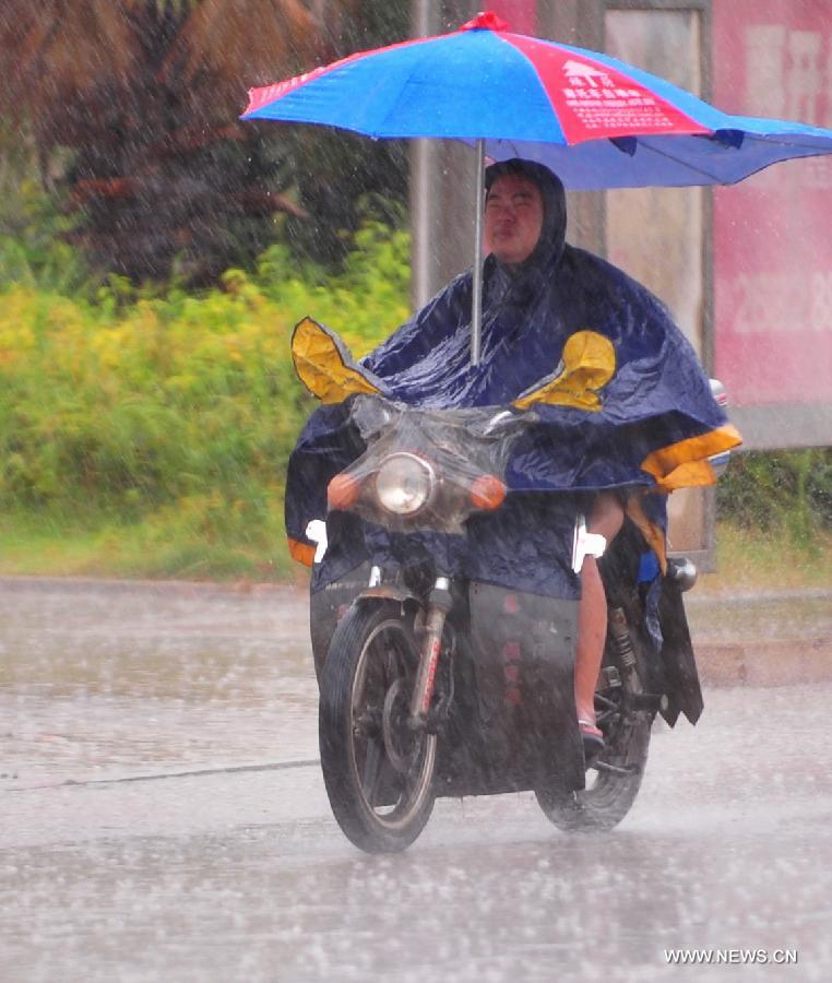 A man rides a motorcycle against the rainstorm in the Luoyuan County, southeast China's Fujian Province, July 13, 2013. The local meteorological authority issued a red alert against typhoon as Typhoon Soulik approaches, bringing strong wind and rainstorms to the region. (Xinhua/Wei Peiquan) 